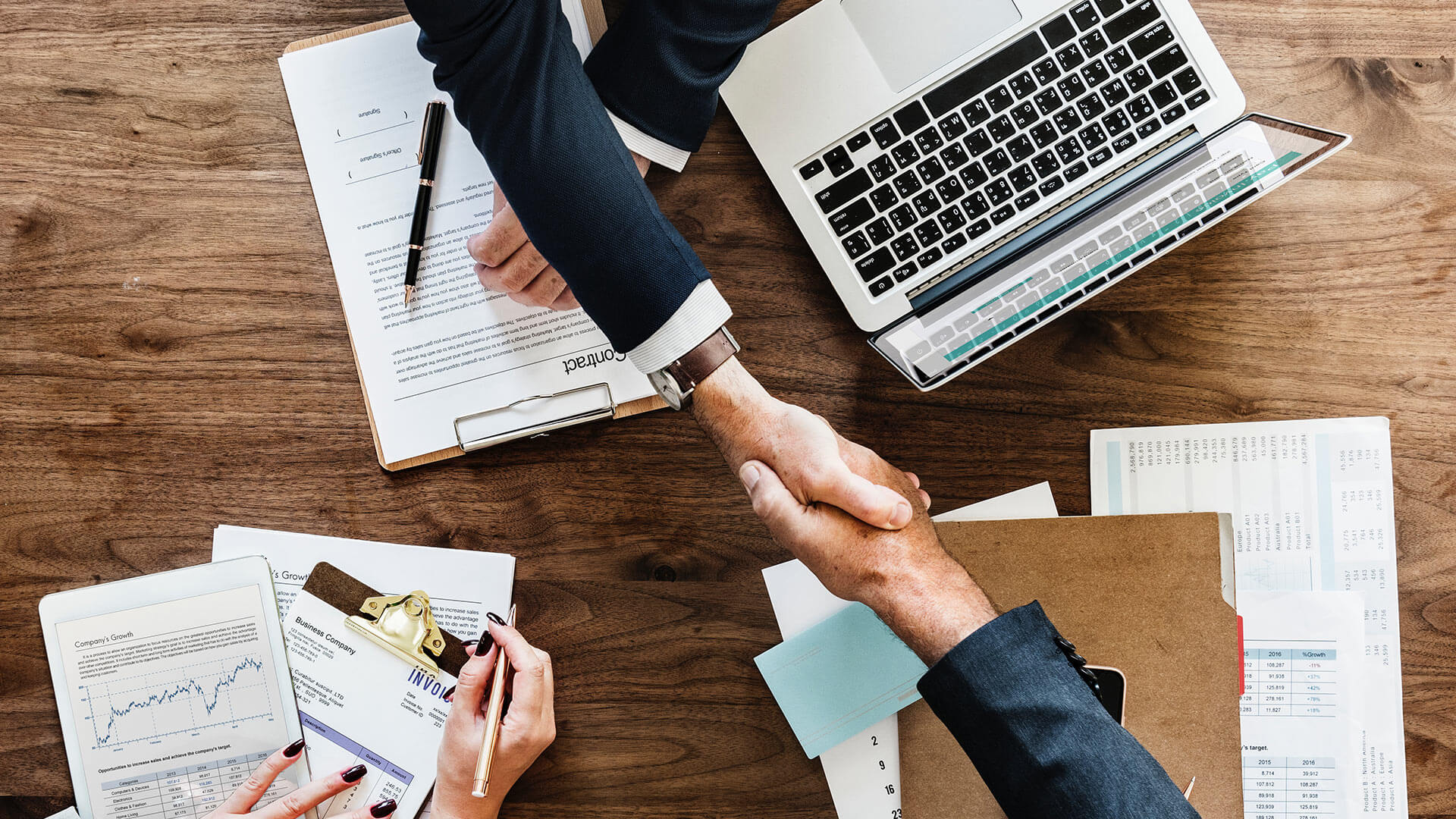 hands shaking across table in business meeting