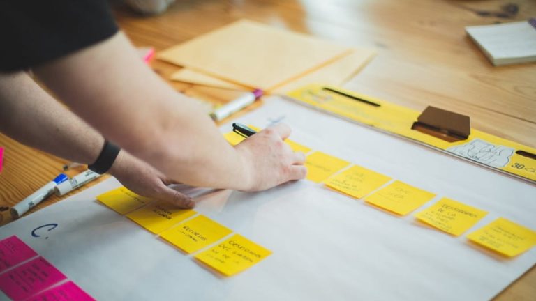 Person writing ideas on sticky notes