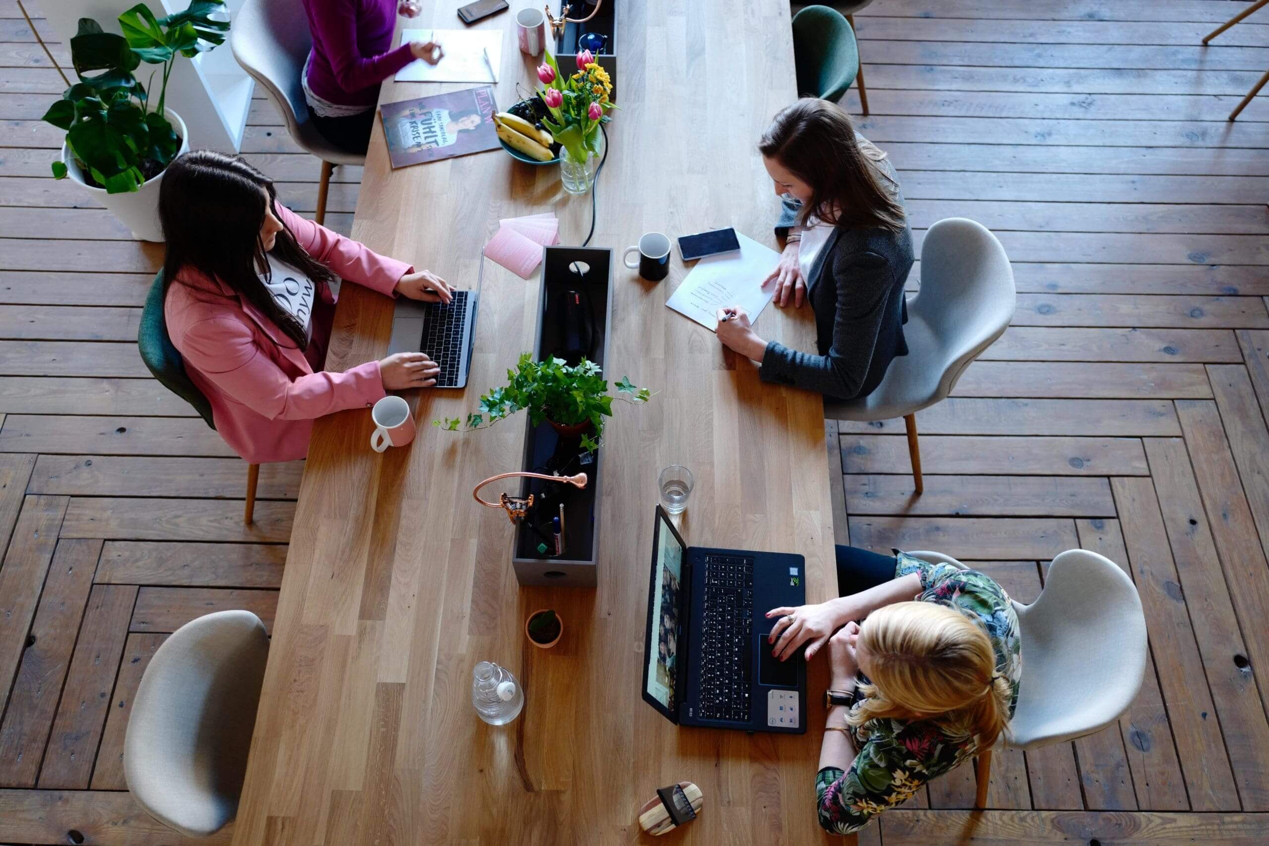 women working with laptops at a table