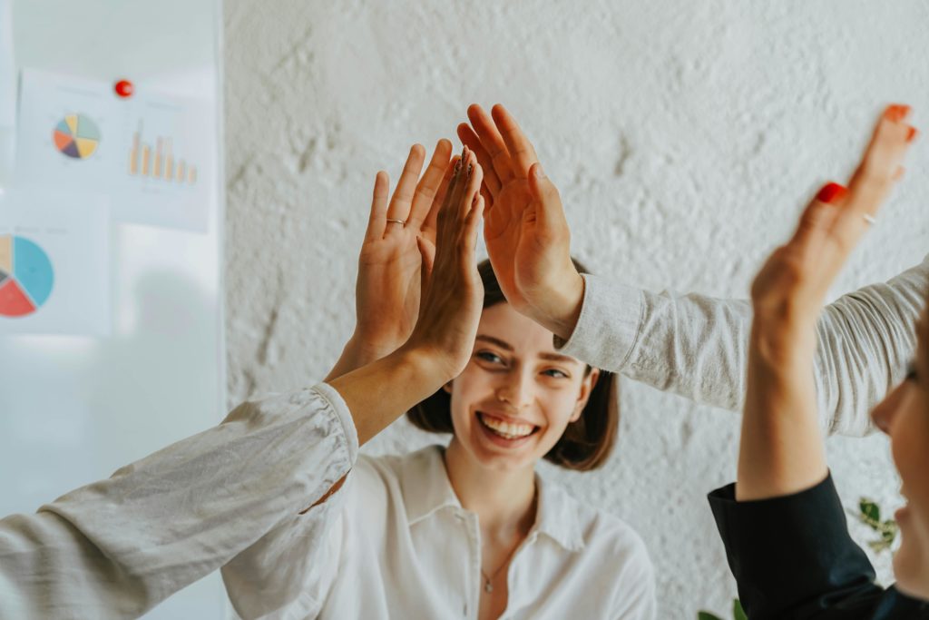 work team celebrating high five in the office