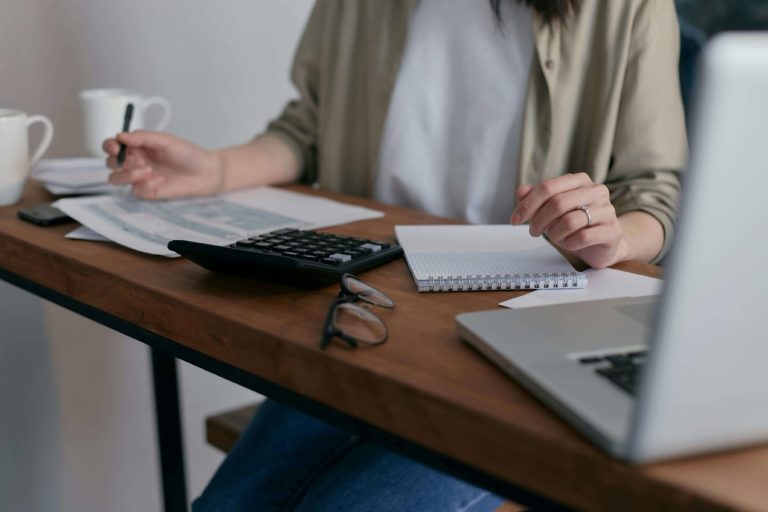 woman at her desk with laptop and papers