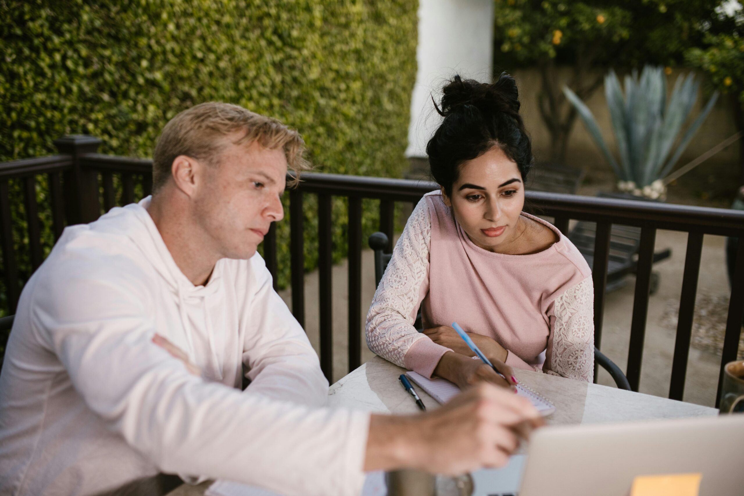 man pointing to laptop and discussing with woman